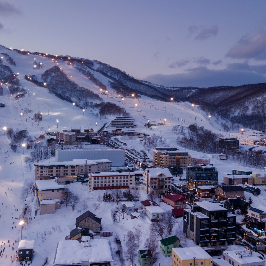 A bird’s eye view of ski resorts on the snowy hillsides in Niseko in the early evening 