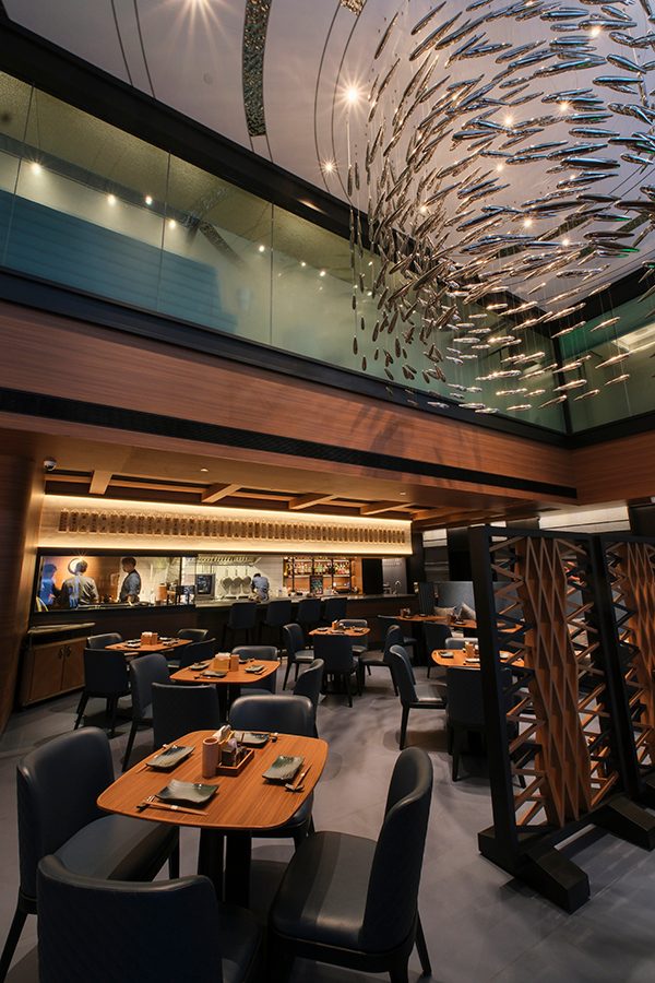 A view inside Akatsuki Izakaya in Hong Kong, featuring modern interior design and a large, silver hanging ceiling decor.