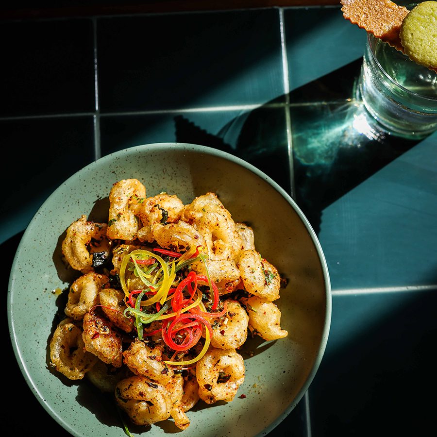 A top-down view of a shrimp dish and cocktail, served at Bar Kin-Rü in Hyderabad