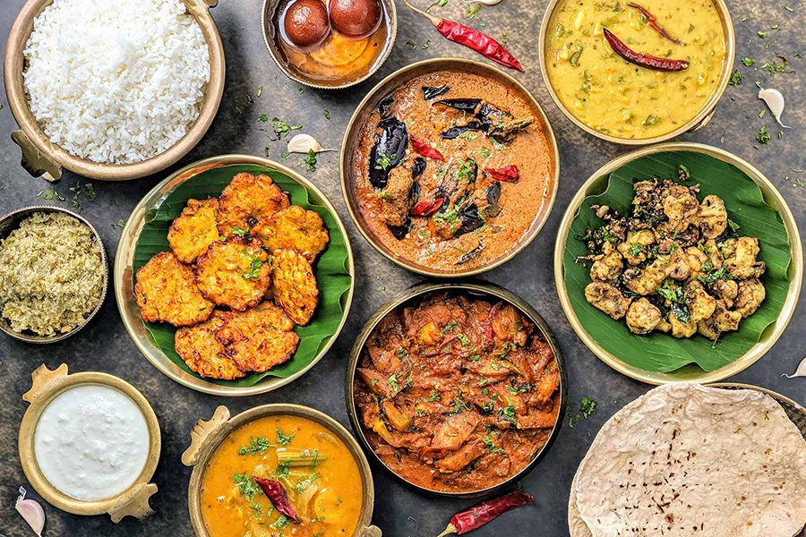 A top-down group shot of various curried dishes, appetisers, rice, pratha, gulab jamun and sauces, served at Rayalaseema Ruchulu in Hyderabad