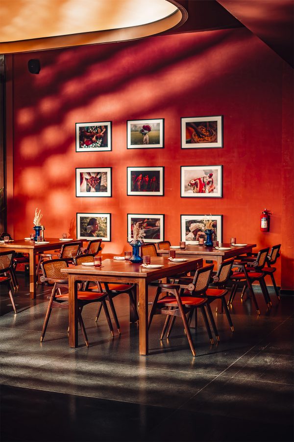 Framed photographs line the orange wall of Terrai neo-telangana kitchen and bar dining area in Hyderabad 