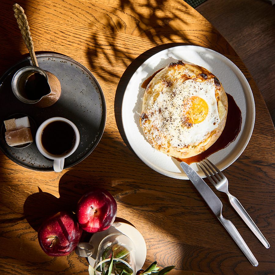 Coffee, apples and a fried egg on a plate served at 21grams in Dubai.