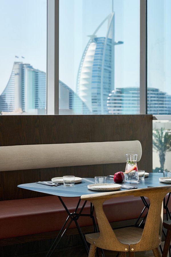 A table at 21grams with a view of Dubai buildings in the window.