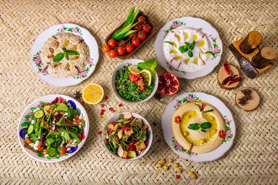 A flatlay of tomatoes, fruits, hummus and other dishes served at Al Khayma Heritage Restaurant in Dubai.