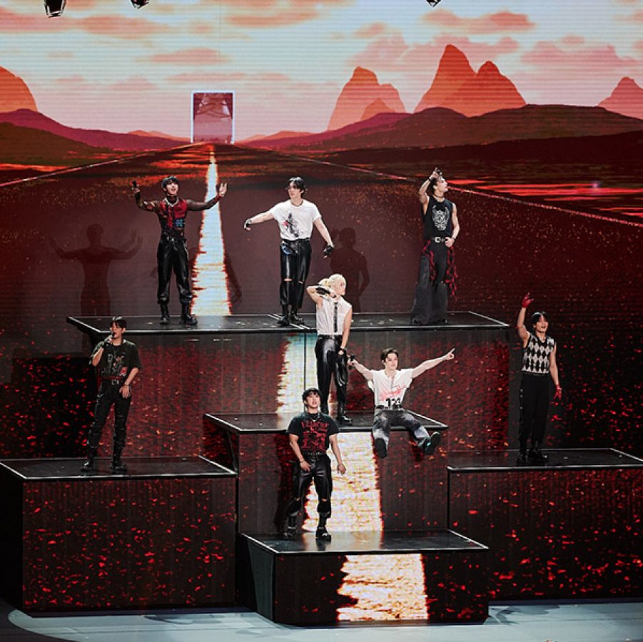 Stray Kids performing on a multi-level platform. 
