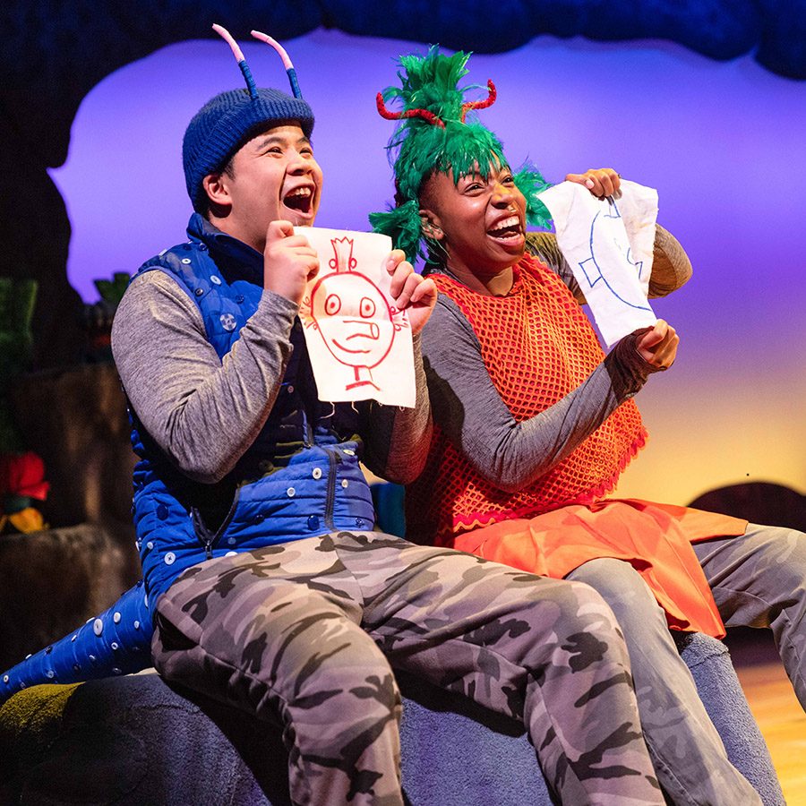 Two actors holding up pictures in The Smeds and The Smoos.