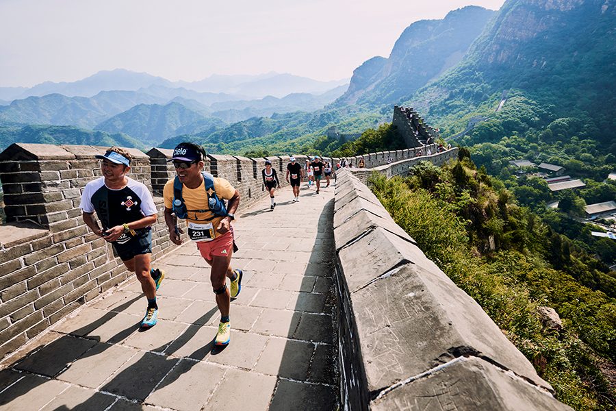Marathon runners on the Great Wall of China in Beijing running for the Great Wall Marathon on a sunny day.