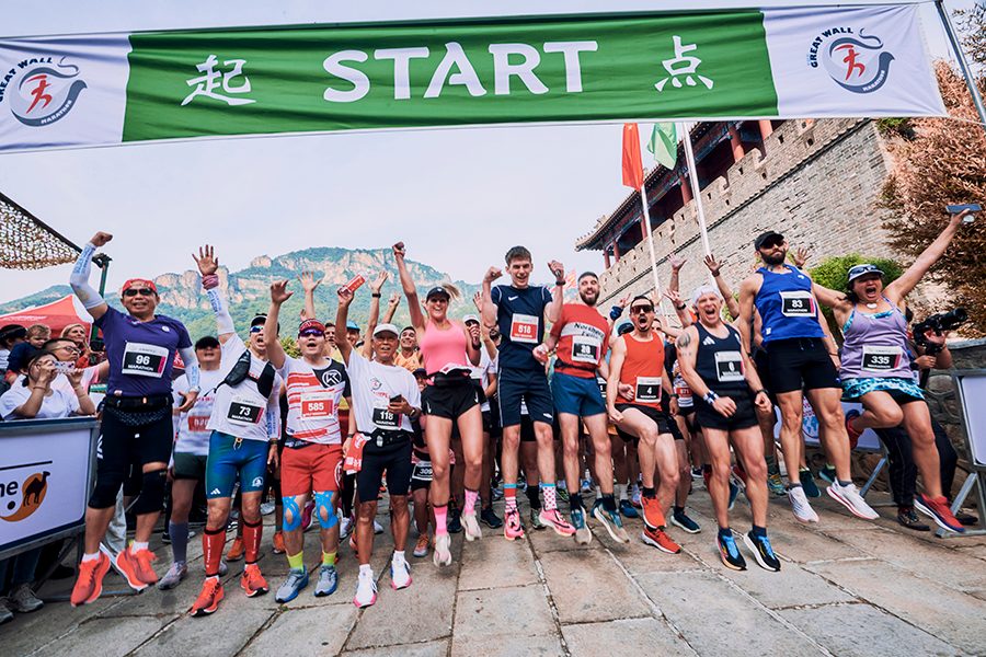 A group shot of runners cheering before the start of the Great Wall Marathon in Beijing, China.
