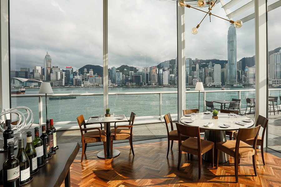 Tables by the window at Harbourside Grill, with a view of Victoria Harbour.