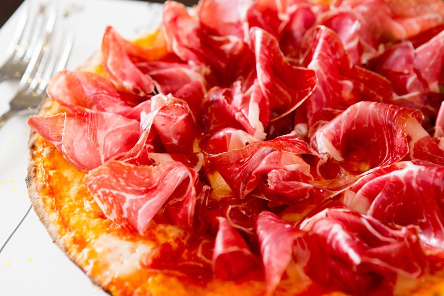 Parma ham on top of a pizza.