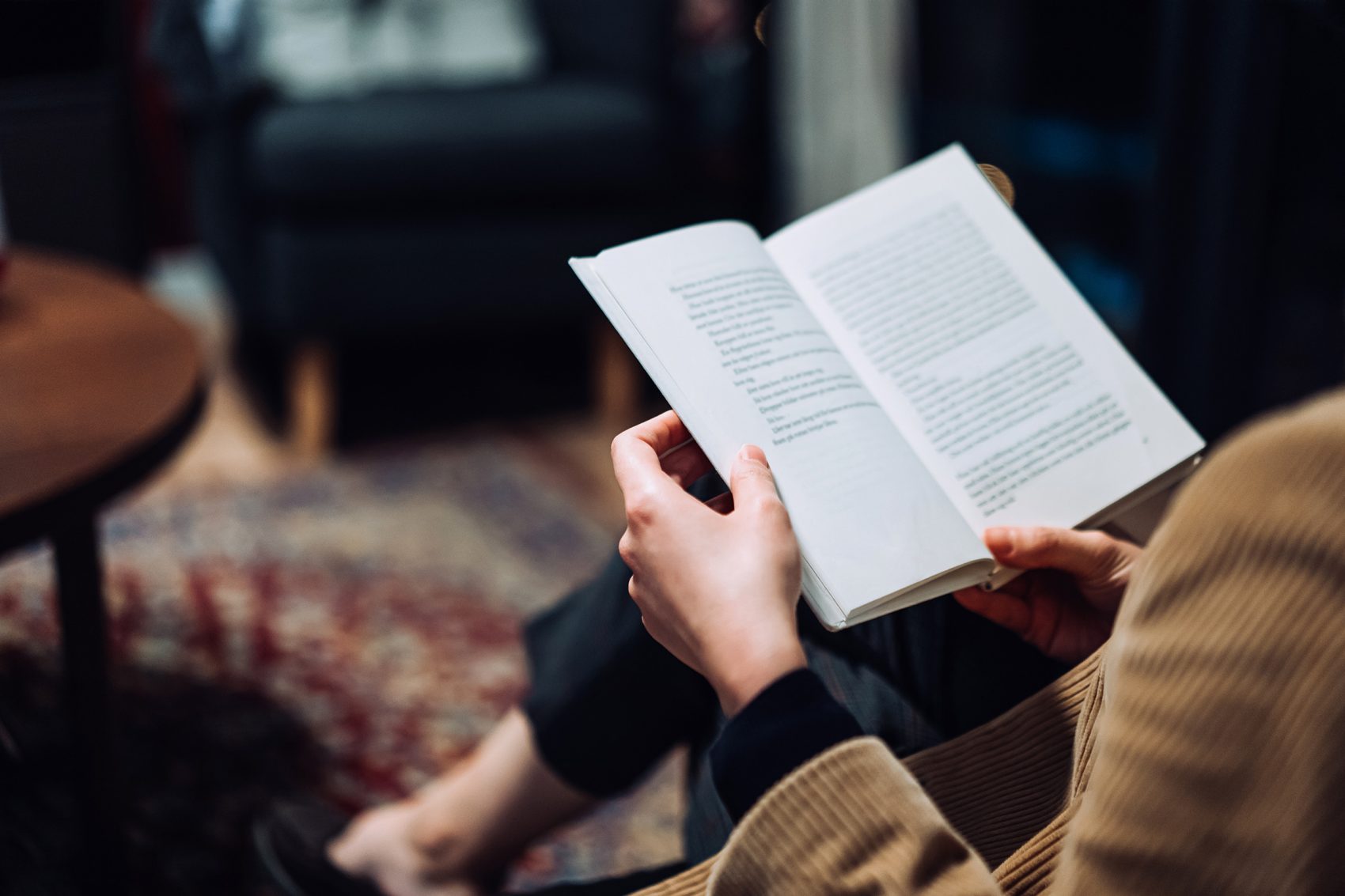 A person reads a book at home.
