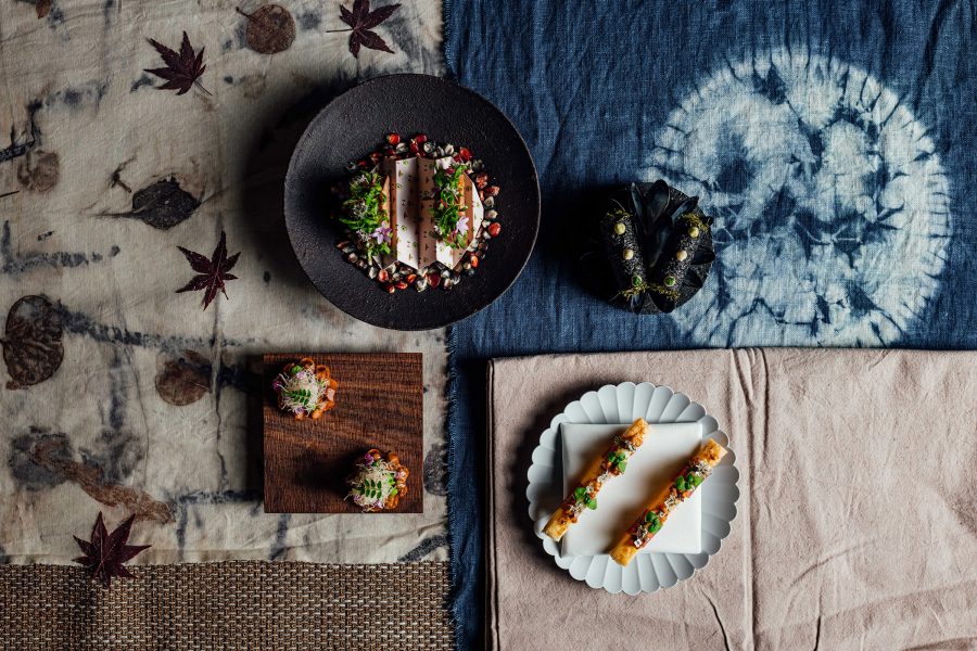 Four plates of food on top of four patterned fabrics. 