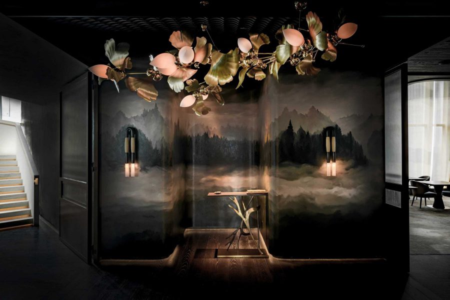 The interior of Ensue, with a floral light fixture and a statement wall depicting California mountains at twilight.