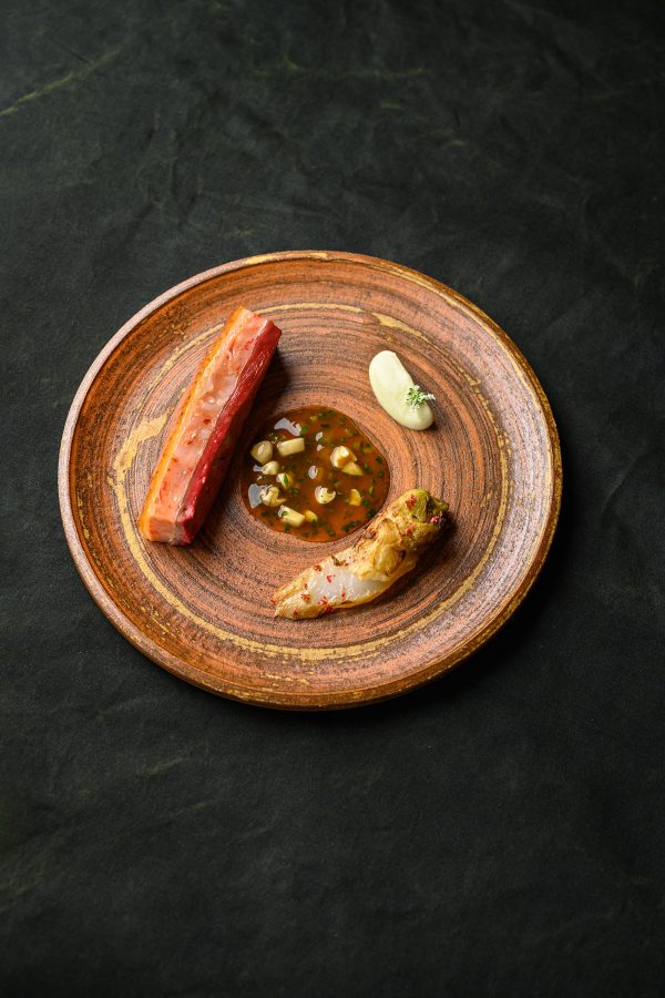 A plate of food on a brown plate at Fumée. 
