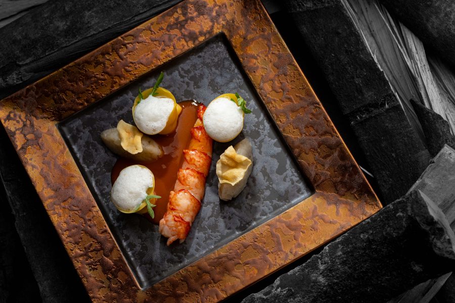 A prawn dish on a black plate at OPUS 388.