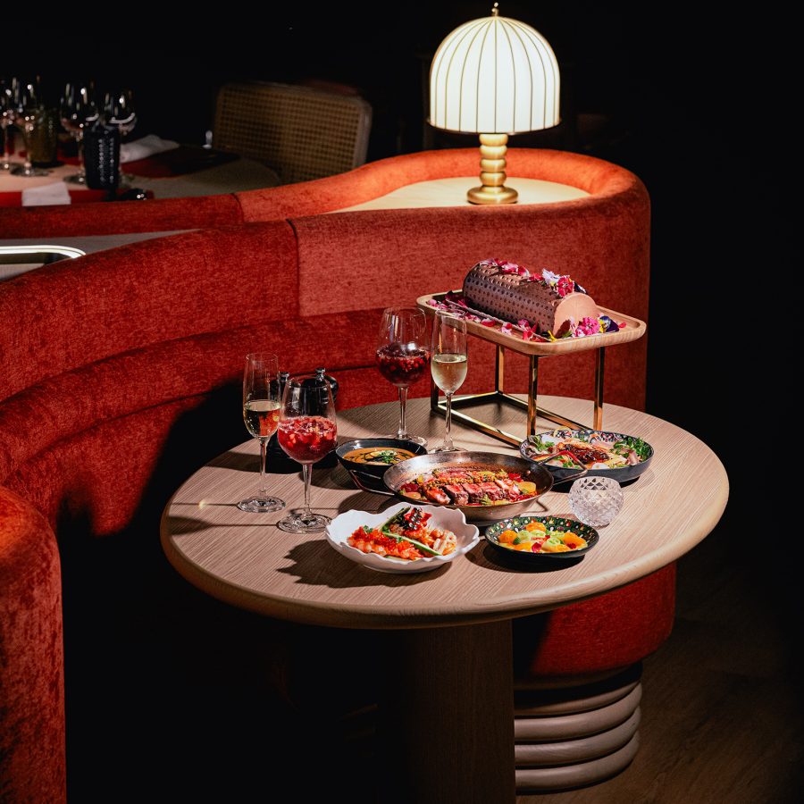A table with plates of food and glasses of wine at Sieto Ocho, the Dorsett Kai Tak, Hong Kong. 
