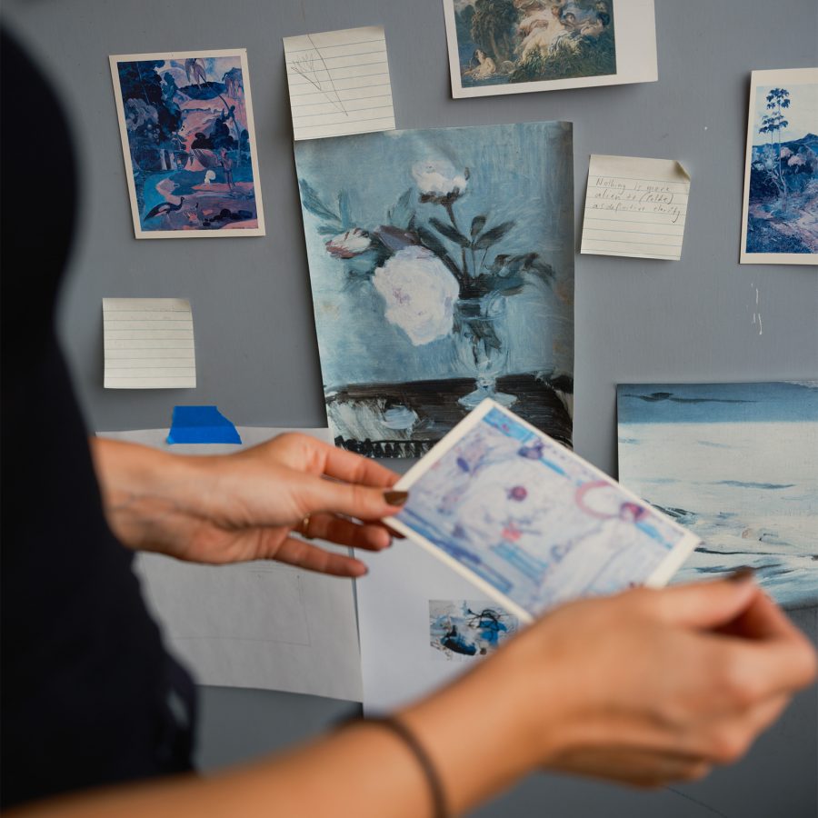 Close-up of a person pinning a photograph to a noticeboard 