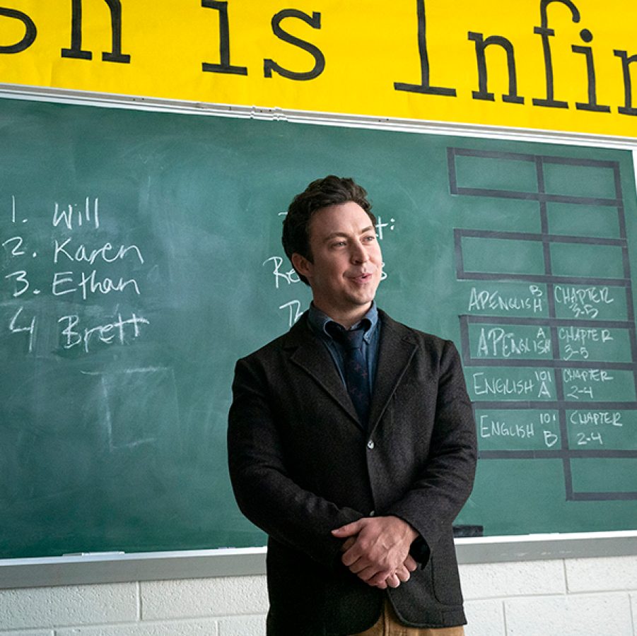  In a scene from TV series English Teacher, teacher Evan Marquez (Brian Jordan Alvarez) stands in front of a blackboard in a school classroom. 