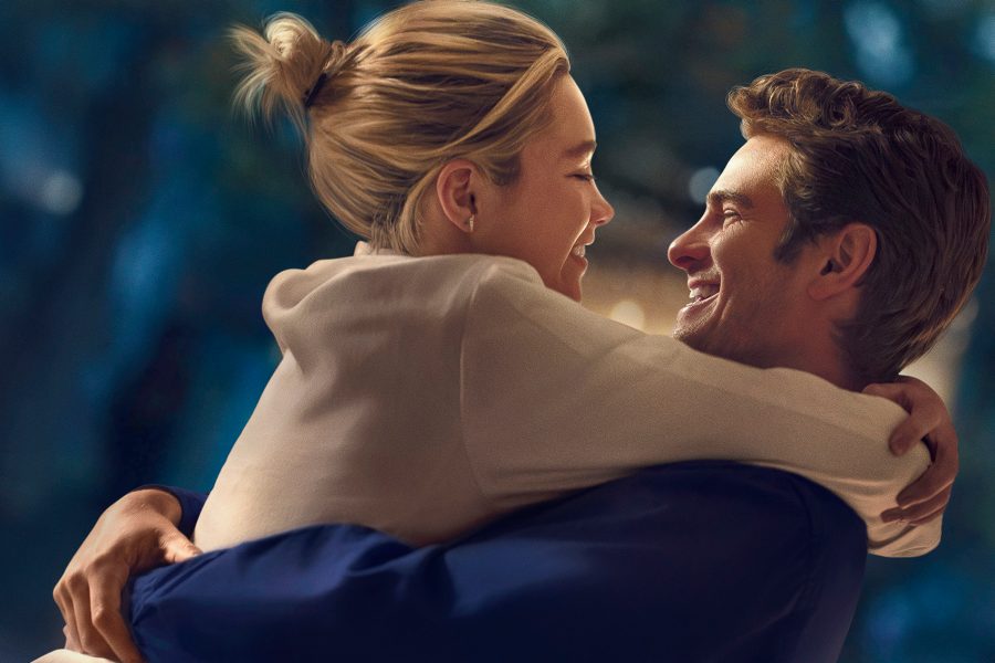 In a scene from the film We Live in Time, young couple Almut (Florence Pugh) and Tobias (Andrew Garfield) smile at each other while embracing. 
