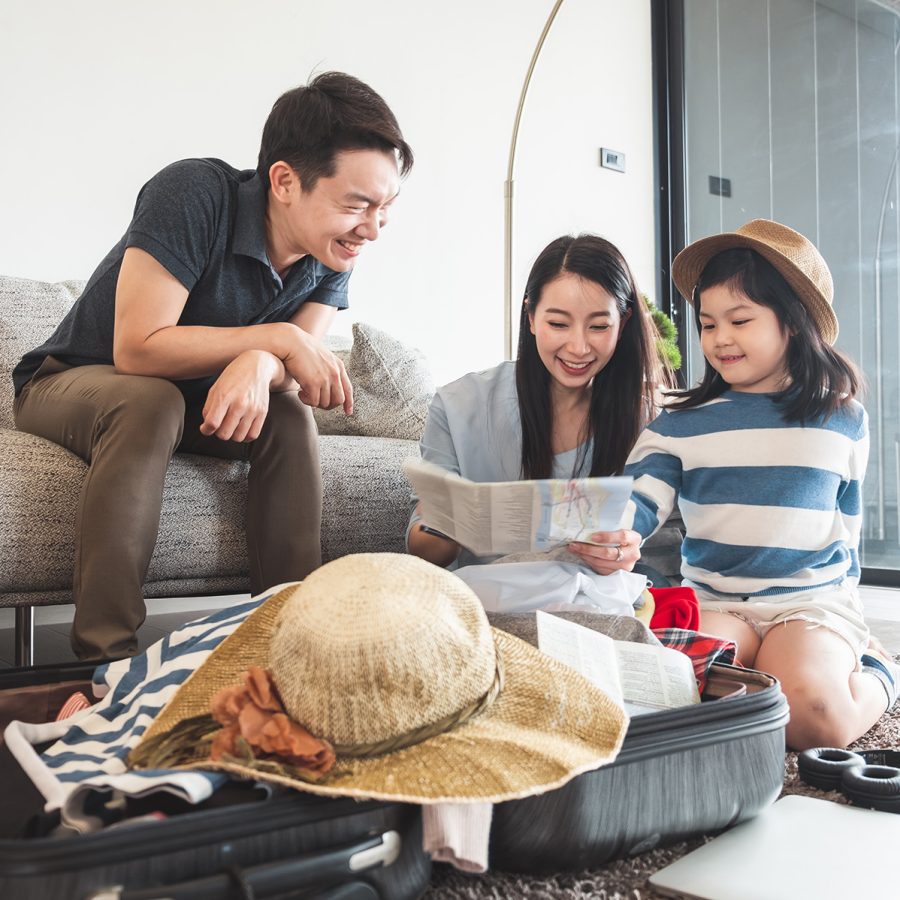 A happy family looking at a map and packing a suitcase together.