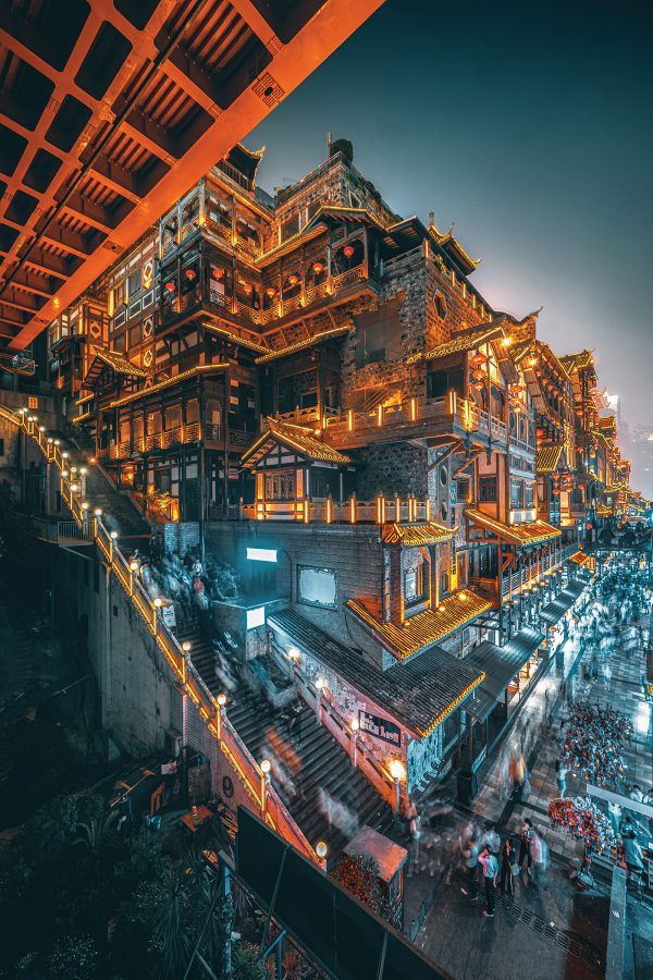 Side view of Chongqing’s Hongya Cave lit up at night.