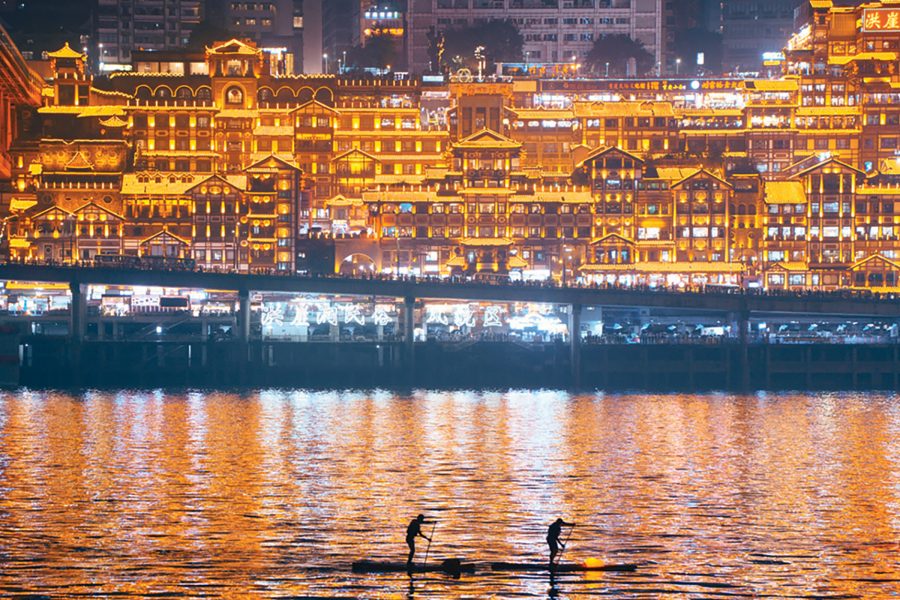 View of Chongqing’s Hongya Cave from the river. The complex is lit up at night. 