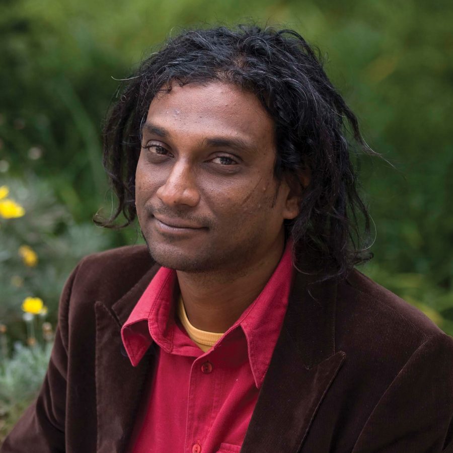 Niren Tolsi smiling in a garden in the daytime.