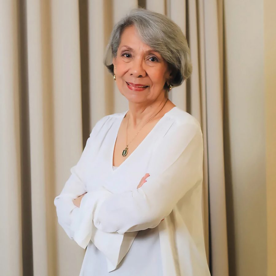 Paulynn Sicam smiling in front of beige curtains.