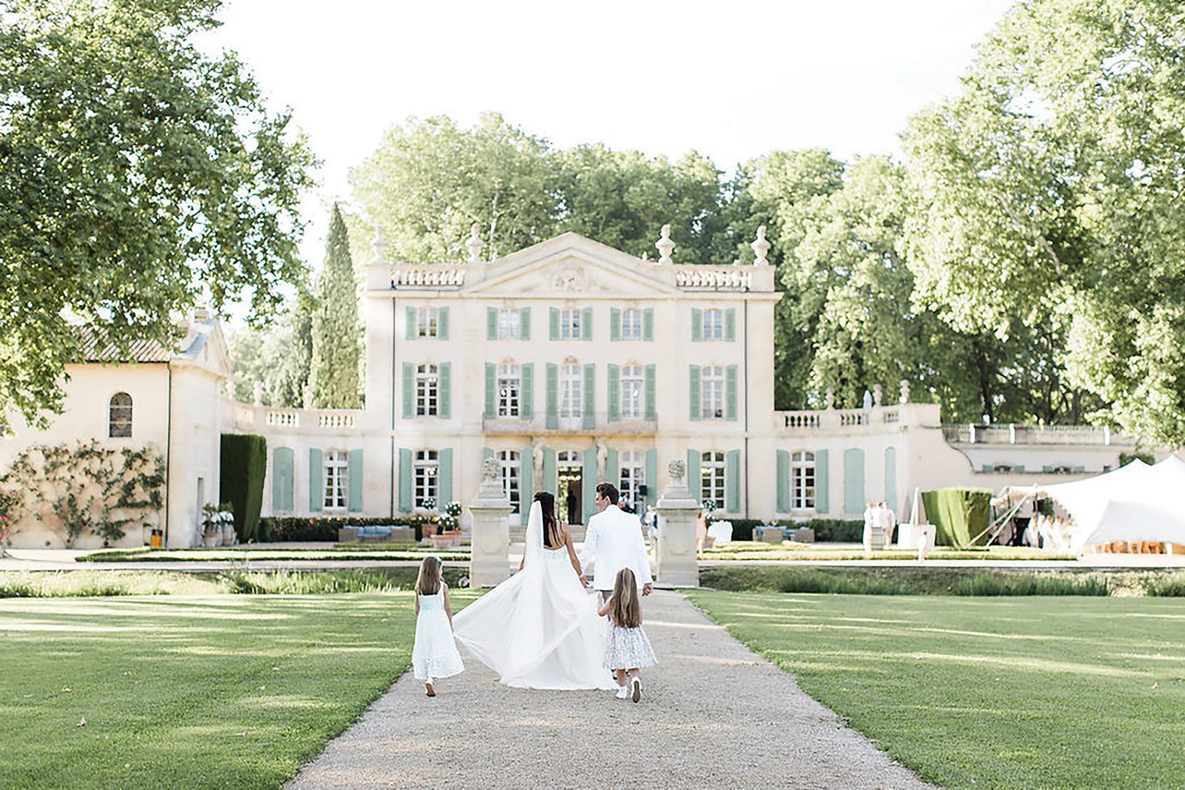 Shot of married couple and children walking towards Chateau de Torreau France