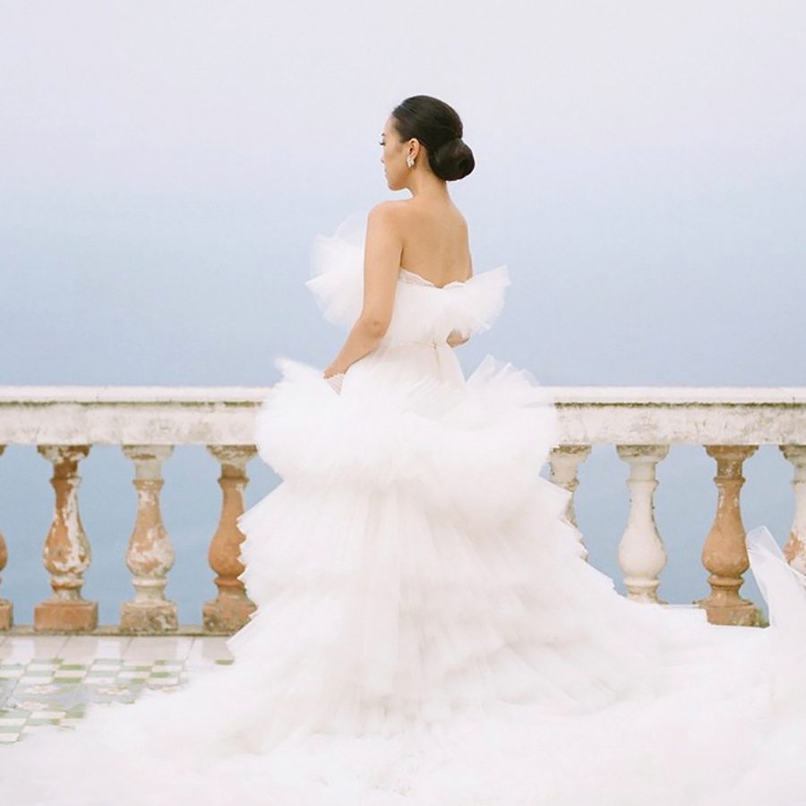 Shot of a bride in a tulle tiered dress on a balcony