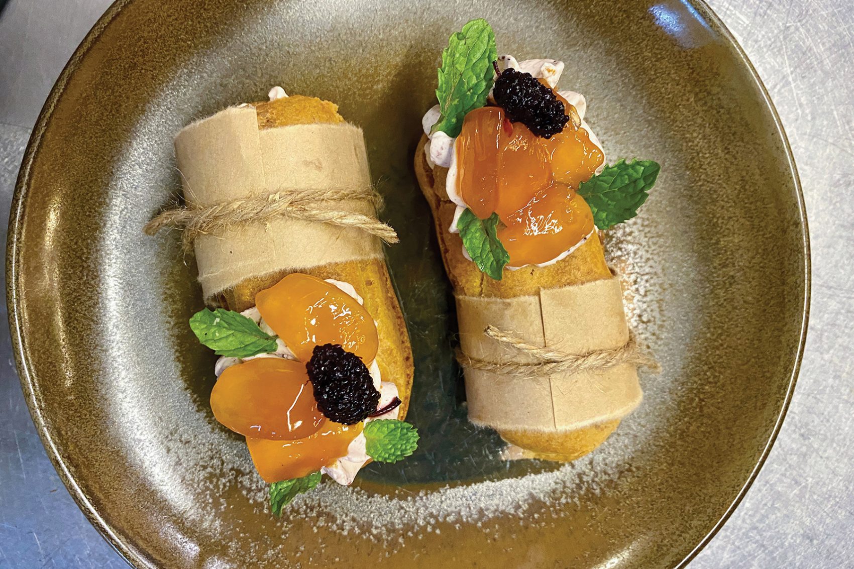 Mini dessert banh mi topped with cream and glazed fruit at Mùa, Hoi An. 