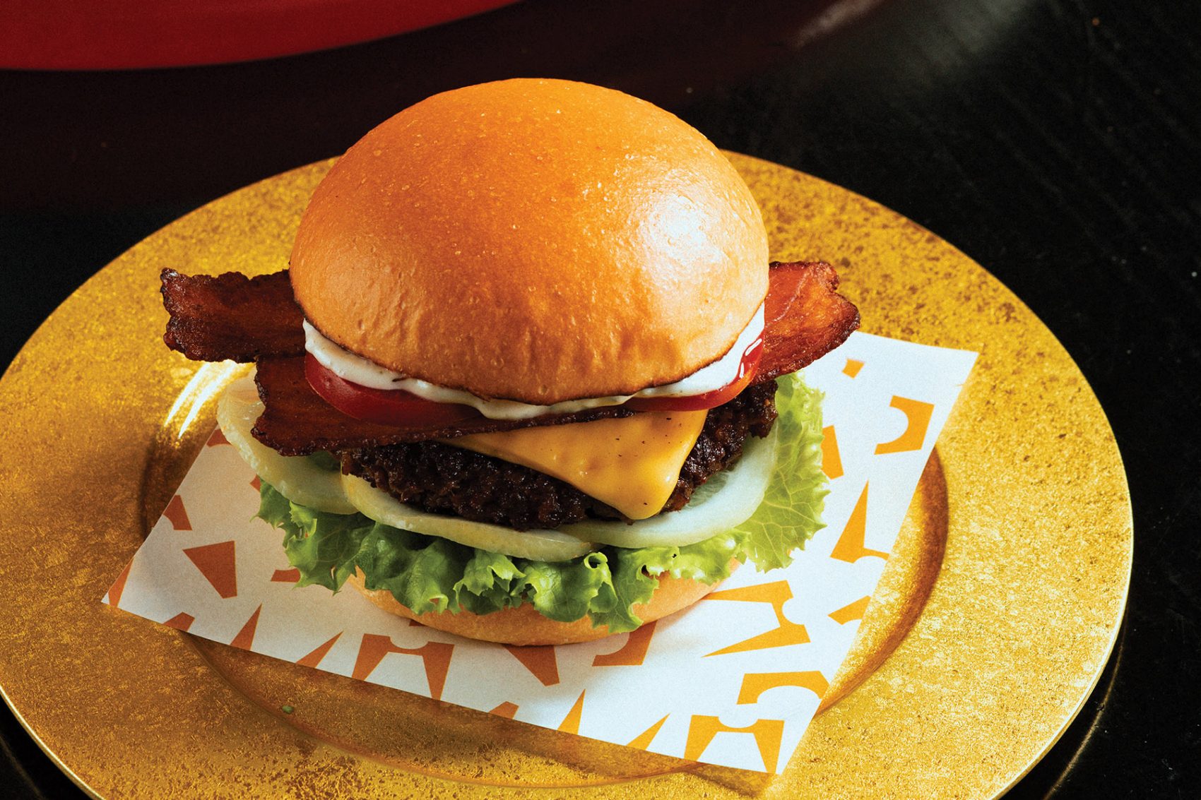 A burger placed on a golden plate at Ngoam, Hanoi, known for its unique take on Hanoi signature foods and other classics. 