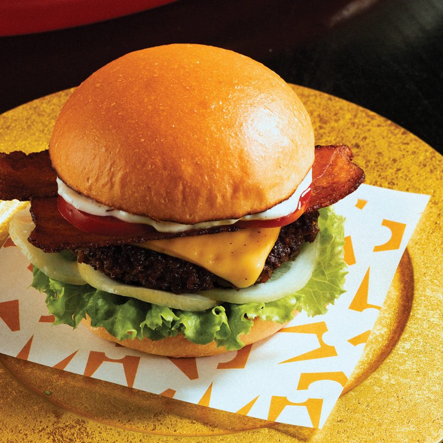 A burger placed on a golden plate at Ngoam, Hanoi, known for its unique take on Hanoi signature foods and other classics. 