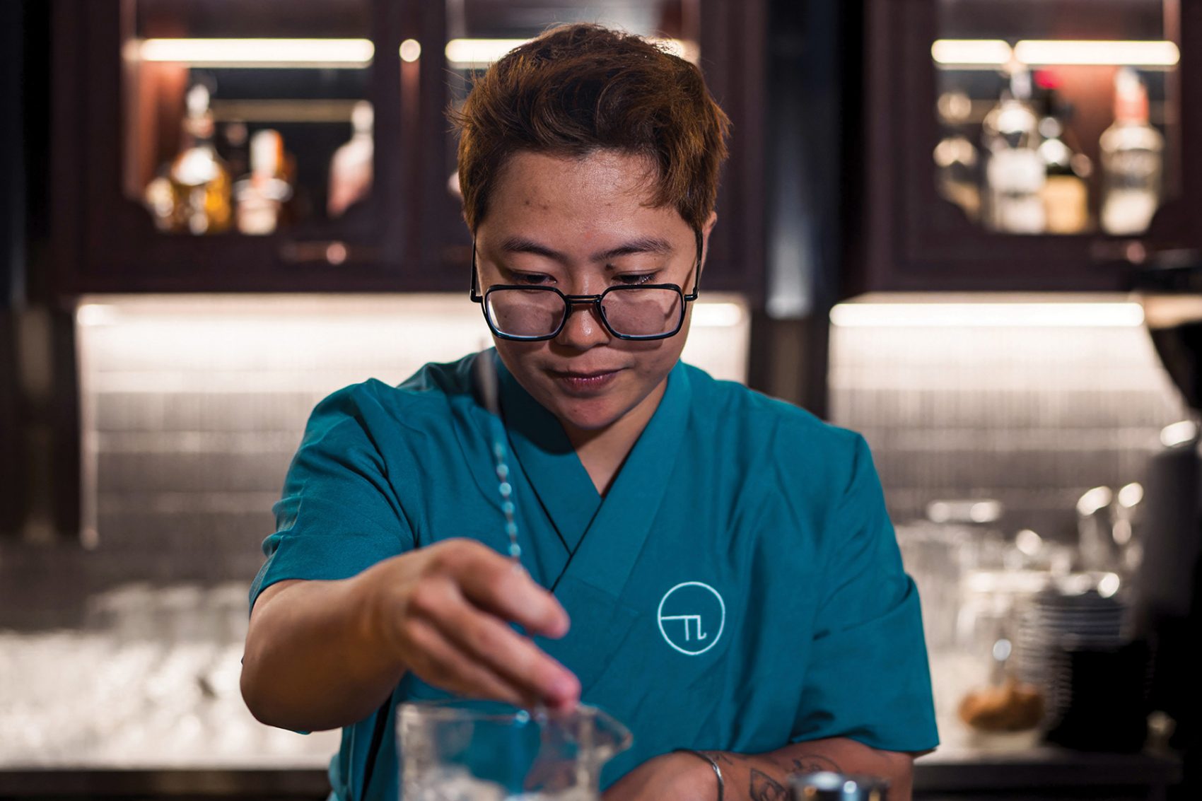 Chun Chun, The Pi’s founder and owner, prepares a drink while sporting the bar’s blue and white colour scheme. 