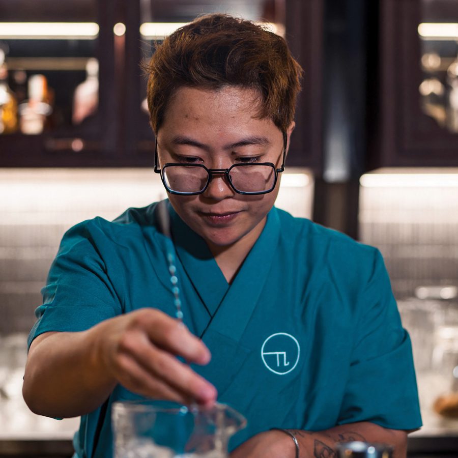 Chun Chun, The Pi’s founder and owner, prepares a drink while sporting the bar’s blue and white colour scheme. 