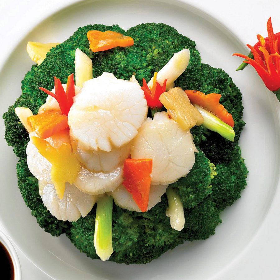 A flatlay close up of a plate of broccoli and scallops served at The Royal Garden Chinese Restaurant in Hong Kong.