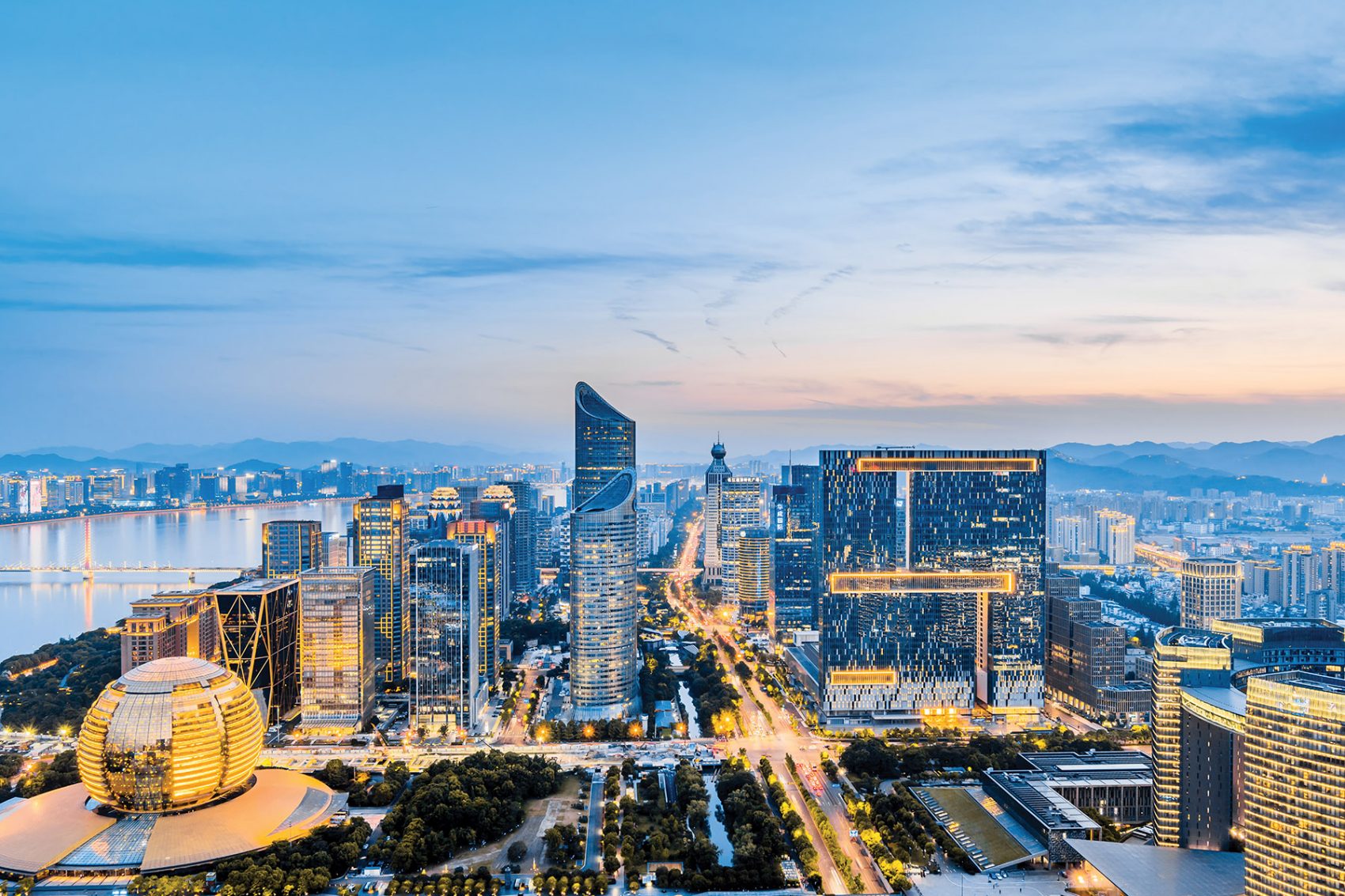 The skyscrapers of Hangzhou’s business district, tinted blue light at dusk.