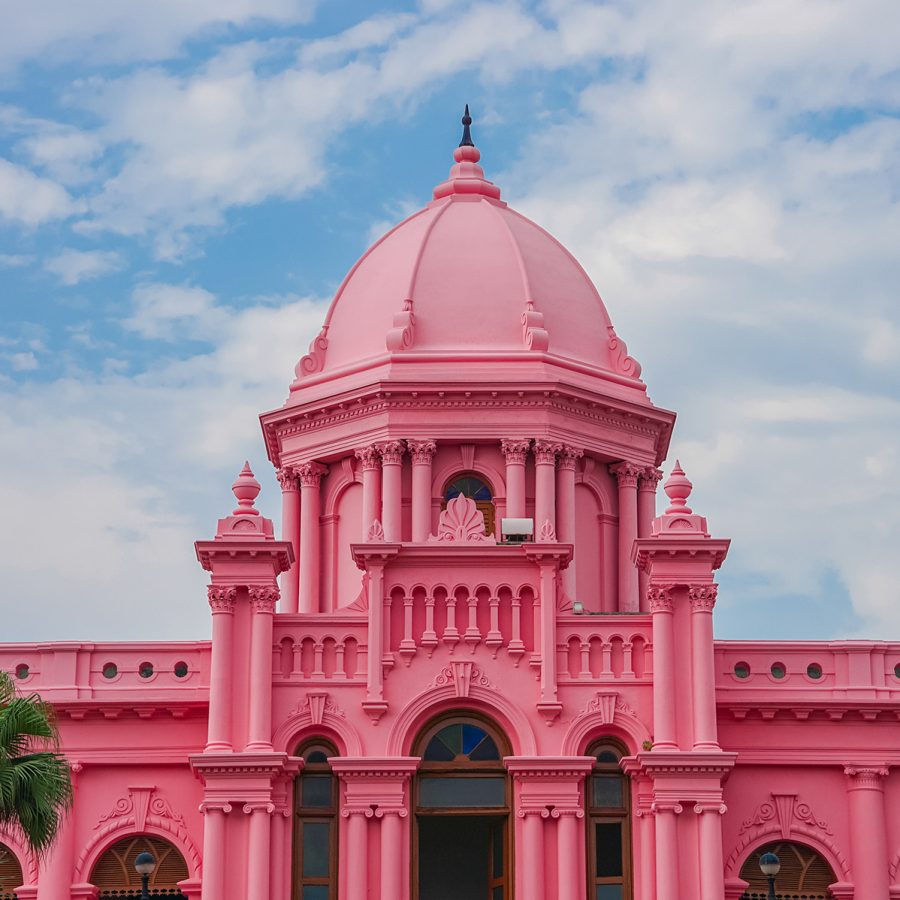 A view of the pink exterior of Ahsan Manzil museum in Dhaka, Bangladesh on a sunny day.