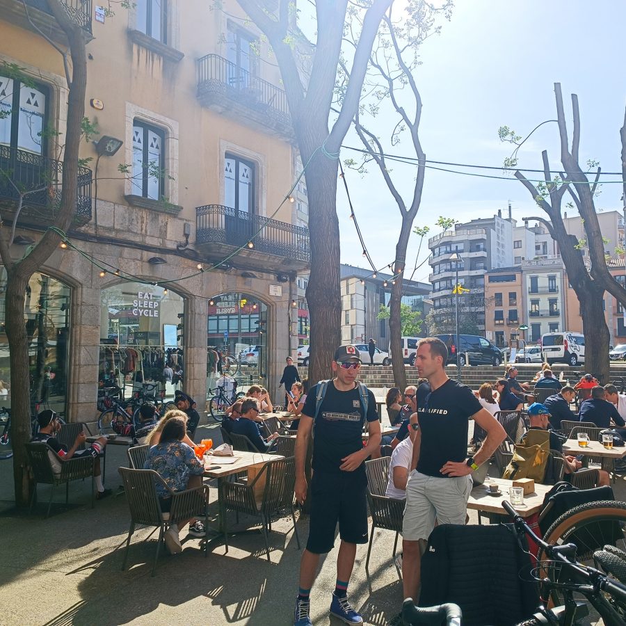 People sitting at tables outside Eat Sleep Cycle Café in Girona.