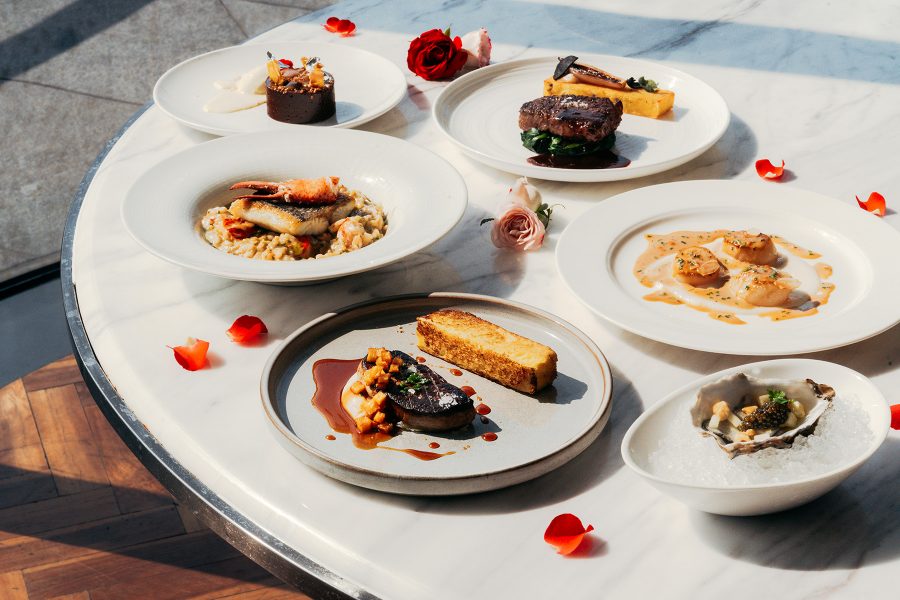 Group shot of multiple dishes surrounded by flower petals at Harbourside Grill,