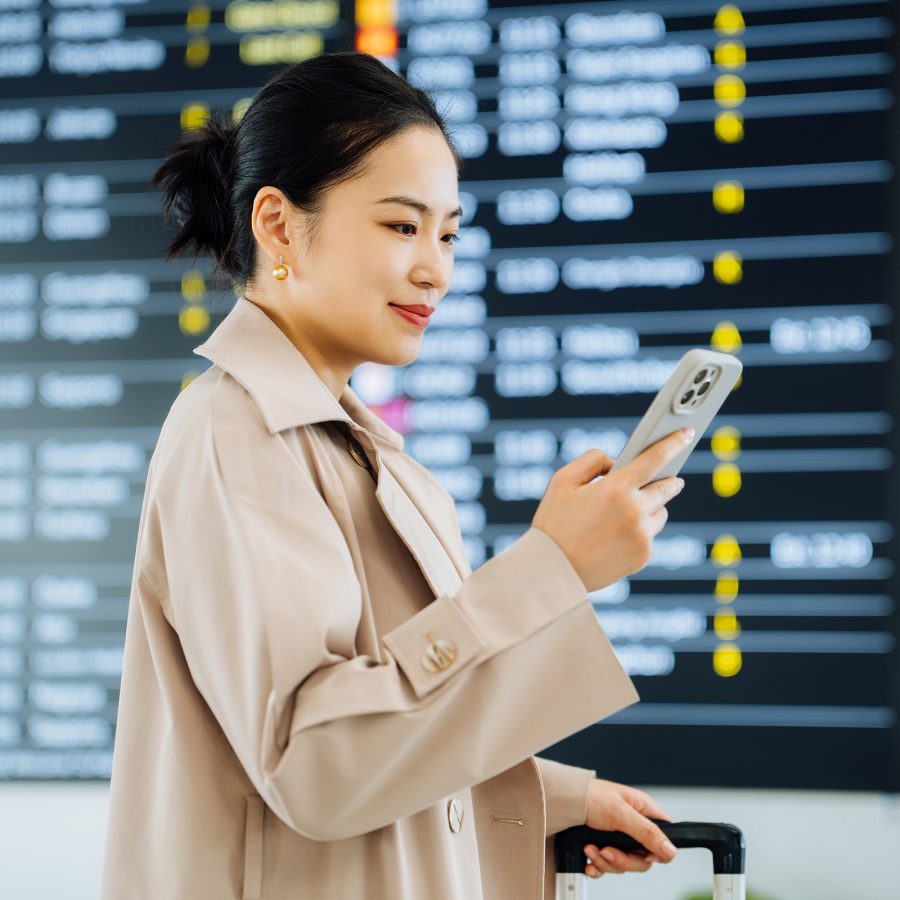 A lady checking her phone in departure hall.