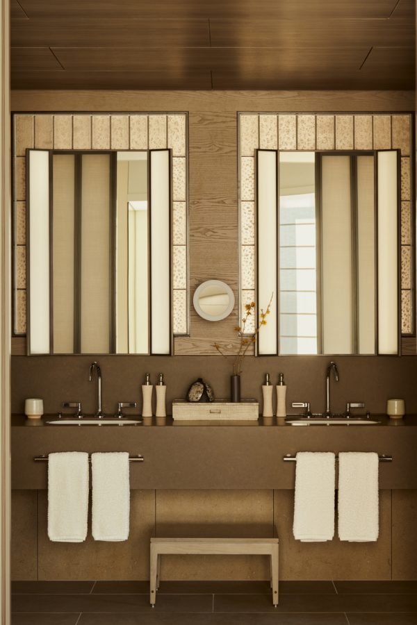 A bathroom at Janu Tokyo is equipped with vanity mirrors, towels and other reusable toiletries. 