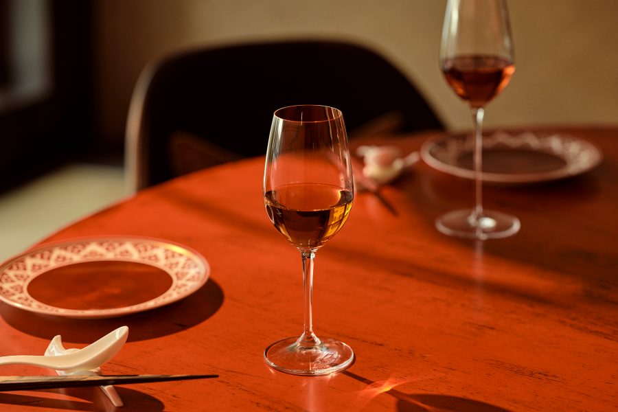 Two glasses of wine are placed on a dining table at Janu Tokyo.  