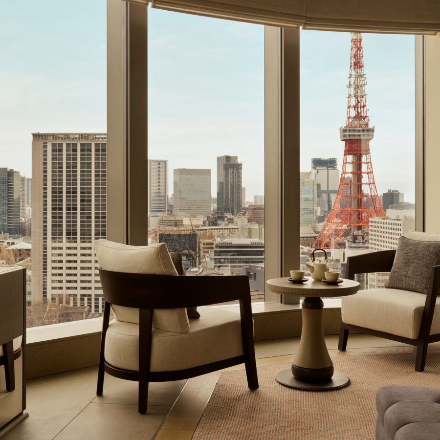 A guest room at Janu Tokyo with floor-to-ceiling windows shows views of Tokyo Tower. 