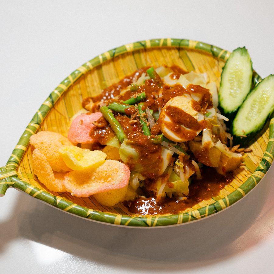 A closeup of a plate of nasi campur with beed rendang and side dishes with a glass of es kolang kaling with palm seed and red syrup served at Warung Malang in Causeway Bay.