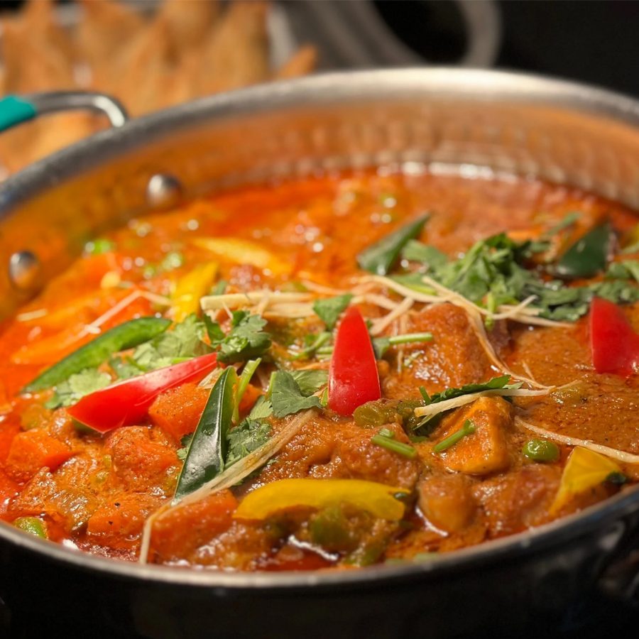 A closeup of a curry dish and samsosa in the background served at Marina Kitchen inside Hong Kong Ocean Park Marriott Hotel.