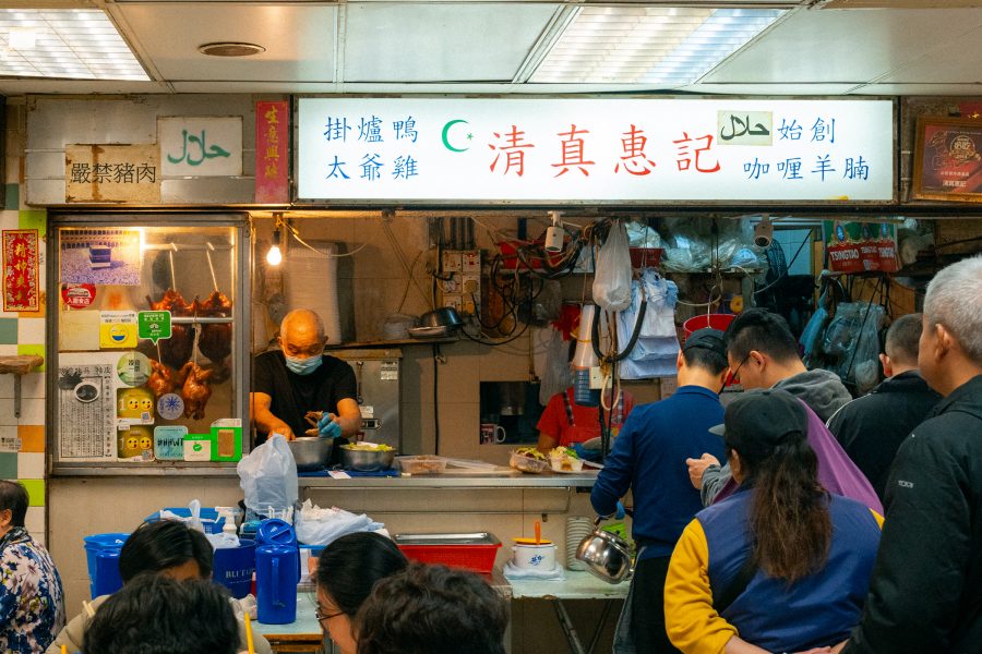 A crowd of people dining and lining up to order at Wai Kee halal duck restaurant at Bowrington Road Market and Cooked Food Centre in Wan Chai.