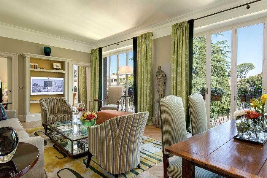 An interior view of the large living room inside the bedroom suite at Hotel de Russie in Rome, complete with large windows.