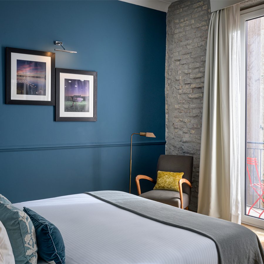 An interior view of a blue bedroom at The Fifteen Keys with a view of the balcony.