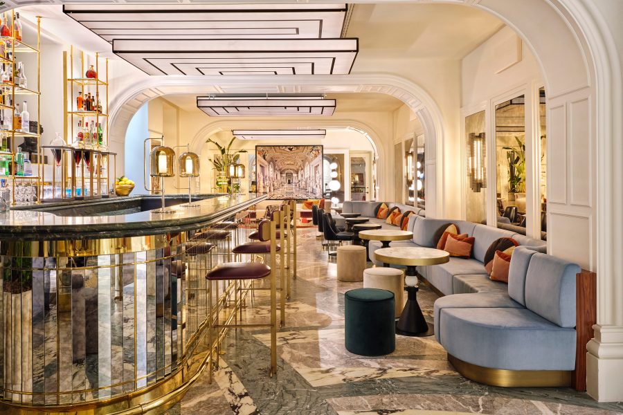An interior view of the luxurious W Rome Bar, decorated with gold and marble.